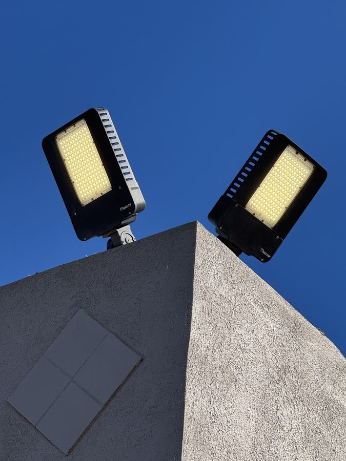 Pair of exterior LED flood lights on a parking lot pylon